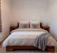 Schlafzimmer mit Bett und Holzmöbeln in einer 2-Zimmer-Wohnung, Boden mit Holzdekor.