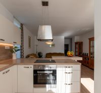 Küche in einer 2-Zimmer-Wohnung mit Holzboden und weißen Schränken.