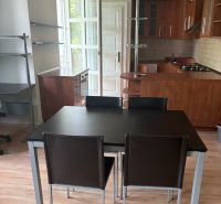 2-Zimmer-Wohnung mit Küche und Esszimmer, Holzboden mit Holzdekor, Möbel aus dunklem Holz.