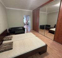 Schlafzimmer mit Doppelbett, Spiegelschrank und Holzboden in einer 2-Zimmer-Wohnung.