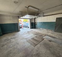 In der Garage mit offenen Türen, Betonboden. Ohne Auto.
