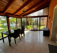 Eine verglaste Terrasse in einem Einfamilienhaus mit Blick auf den Garten.