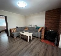 Wohnzimmer in einem Einfamilienhaus mit Holzboden und Kachelofen.