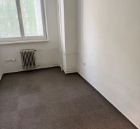 Büro mit Teppichboden, Heizkörper und Fenster mit Jalousien.