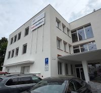 Ein Bürogebäude in der Dlhá-Straße in Prievidza mit geparkten Autos.