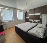 Schlafzimmer in einer 2-Zimmer-Wohnung mit Bett und Schrank, Boden mit Holzdekor.