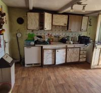 Küchenbereich in einem Einfamilienhaus mit Holzboden und rustikaler Dekoration.