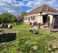 Žiadna Dedinka: Einfamilienhaus mit Garten und Anbau, mit einem Rasenmäher auf dem Rasen.