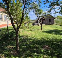 Ein Einfamilienhaus in Dedinka mit einer verglasten Veranda, einem Garten und einem Holzbau im Hof.