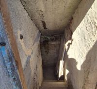 Ein düsterer Treppenhausflur in einem Einfamilienhaus mit einer beschatteten Wand.