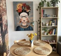 Esszimmer in einer 2-Zimmer-Wohnung mit einem Bild, einem Holztisch und dekorativen Accessoires.