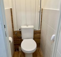 Toilette in einer 2-Zimmer-Wohnung mit Holzboden.