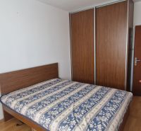 Schlafzimmer in einer 2-Zimmer-Wohnung mit Bett, Kleiderschrank und Holzboden.