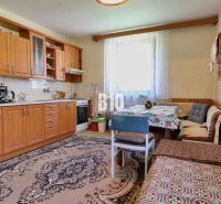 Küche in einem Einfamilienhaus mit Holzmöbeln und Essecke.