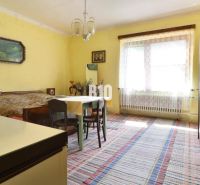 Ein Zimmer in einem Einfamilienhaus mit gelben Wänden, einem Tisch und einem Bett.