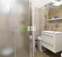 Badezimmer in einem Einfamilienhaus mit Waschbecken und Duschkabine.