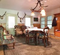 Innenraum eines Einfamilienhauses mit Holzverkleidung und Jagdtrophäen an den Wänden.