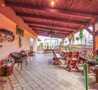 Die Terrasse des Einfamilienhauses in Lukáčovce mit Holzsitzgelegenheiten und Dekorationen.