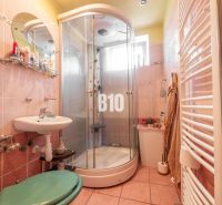 Badezimmer mit Dusche und rundem Spiegel in einem Einfamilienhaus.