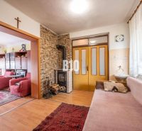 Wohnzimmer in einem Einfamilienhaus mit Kachelkamin und Boden mit Holzdekor.