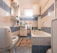 Ein Badezimmer in einem Einfamilienhaus mit einer Badewanne und blauen Fliesen.