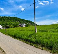 Hügelige Landschaft bei Fintice mit Baugrundstücken und ländlicher Umgebung im Hintergrund.