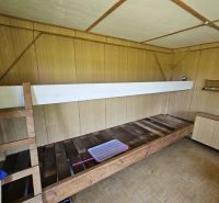 Das Innere der Hütte mit einem Etagenbett, einem Boden in Holzoptik und einer Holzwand.
