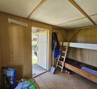 Ein Zimmer in einer Hütte mit einem Etagenbett und einem Boden in Holzoptik.