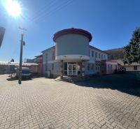 Produktionsräume in Kremnička, Banská Bystrica, umgeben von einem gepflasterten Hof und Bäumen.