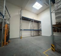 Lagerhallen und Hallen mit hohen Regalen und Dachfenstern, Betonboden.