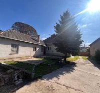 Ein Einfamilienhaus in Vrakúňa mit einem Betondvor und einem großen Nadelbaum.