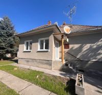 Ein Einfamilienhaus in Vrakúňa mit Rasen, Satellitenschüssel und Antenne auf dem Dach.