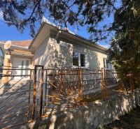 Ein Einfamilienhaus in Vrakúňa mit einem dekorativen Metallzaun und Bäumen im Hintergrund.