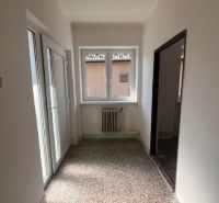 Ein schmaler Flur in einem Einfamilienhaus mit weißen Wänden und französischen Türen.