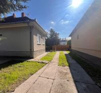 Ein Einfamilienhaus in Vrakúňa mit einem Betonweg und einer Rasenfläche.