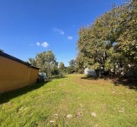 Garten bei einem Einfamilienhaus in Vrakúň mit grünem Rasen und Bäumen.