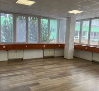 Büros mit Holzboden und großen Fenstern.