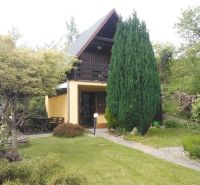 Ein Einfamilienhaus in der Karloveská Straße in Bratislava, umgeben von einem Garten und Grünflächen.