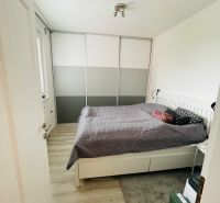 Schlafzimmer in einer 3-Zimmer-Wohnung mit Holzboden und einem großen Schrank.