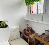 Stillleben mit Stuhl und Pflanzen auf einem gemütlichen Balkon in einer 3-Zimmer-Wohnung.