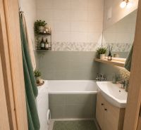 Ein Badezimmer in einer 3-Zimmer-Wohnung mit Badewanne, Waschmaschine und Dekorationen in natürlichen Tönen.