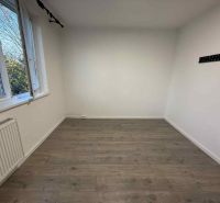 Helles Zimmer mit Holzboden und Heizkörper in einer Vierzimmerwohnung.