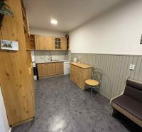 Küche in einer 4-Zimmer-Wohnung mit Holzschränken und einem Boden in Holzoptik.