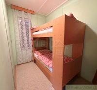Etagenbett im Zimmer der Hütte mit einem Vorhang mit Blumenmuster.
