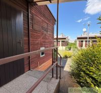 In Nové Zámky, a cottage with a garden, clad in wood, with railings and satellites.