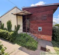 Ein Ferienhaus in Nové Zámky mit Holzverkleidung und Grünfläche im Vorgarten.