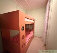 Etagenbett in der Hütte, helles Zimmer mit sanfter Beleuchtung.