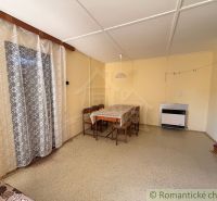 Esszimmer in einer Hütte mit Holzboden und Vorhängen.
