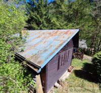 Eine Hütte im Wald bei Slovenská Ľupča, umgeben von Grün und Bäumen.