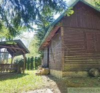 Eine Hütte in Slovenská Ľupča, umgeben von Grün, mit einer Außensitzgelegenheit und Holzelementen.